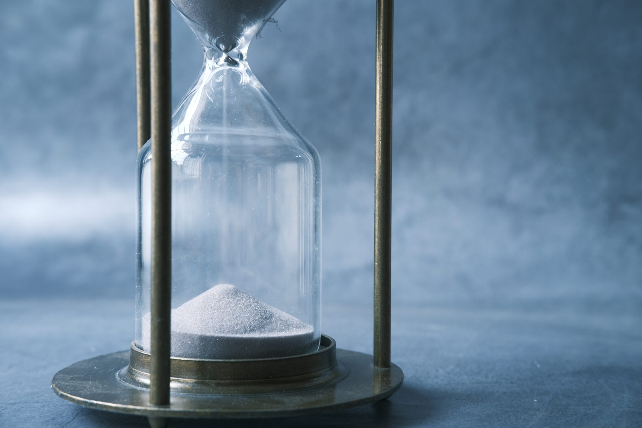 Symbolbild für den zeitintensiven Prozess der Rekrutierung qualifizierter COOs. Eine Sanduhr in Nahaufnahme zeigt rieselnden Sand, der den Verlauf der Zeit symbolisiert. Die Darstellung unterstreicht, dass die Suche nach wirklich guten Chief Operating Officers Geduld und sorgfältige Auswahl erfordert.