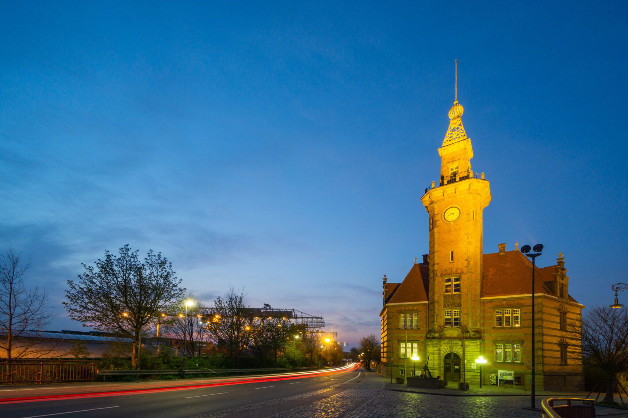 Das Alte Hafenamt in Dortmund bei Dämmerung, beleuchtet von Straßenlaternen.