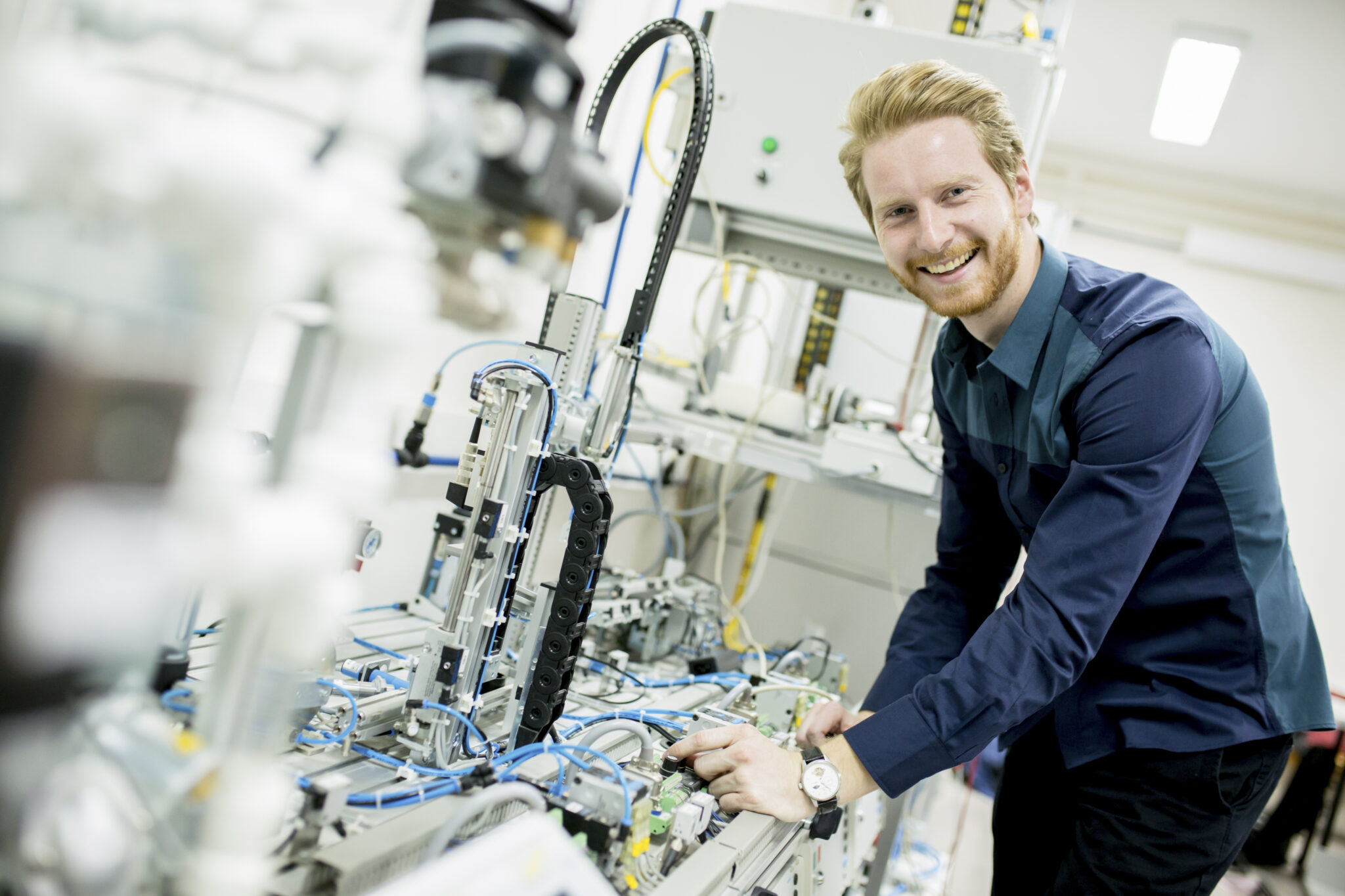 Ingenieur arbeitet motiviert an moderner Maschine, symbolisiert Innovation, Technikbegeisterung und Arbeitsfreude.