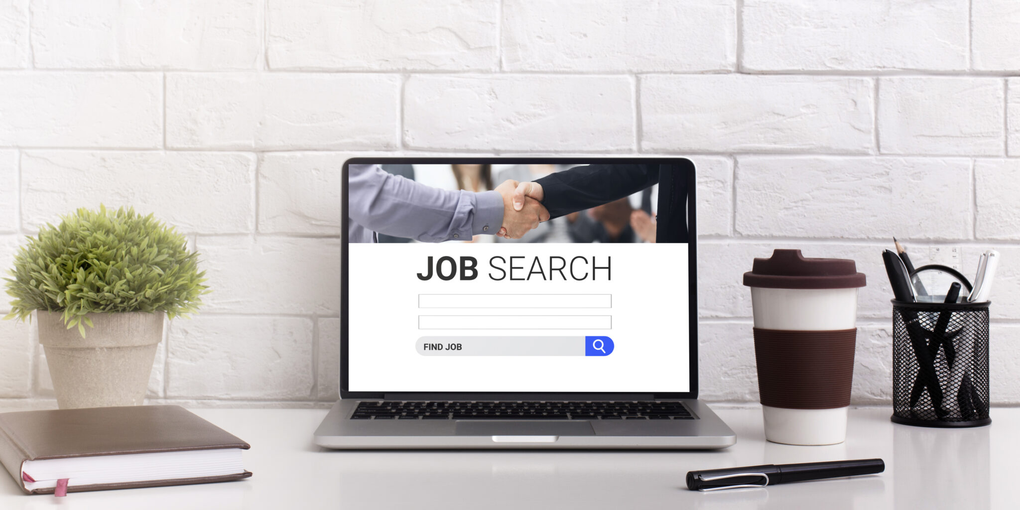 Laptop auf Schreibtisch mit "Job Search"-Anzeige; Symbol für Online-Stellensuche.