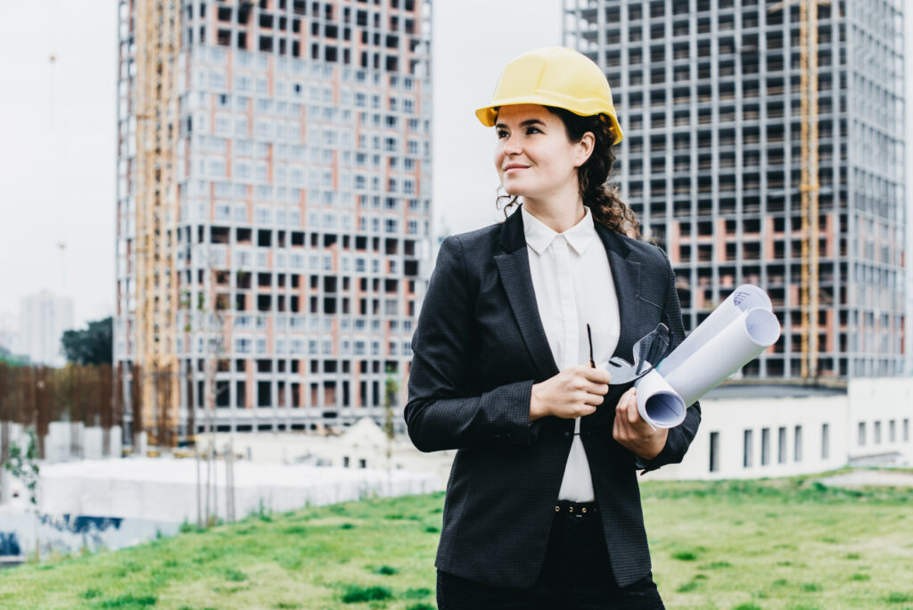 Junge Bauingenieurin vor einer Baustelle