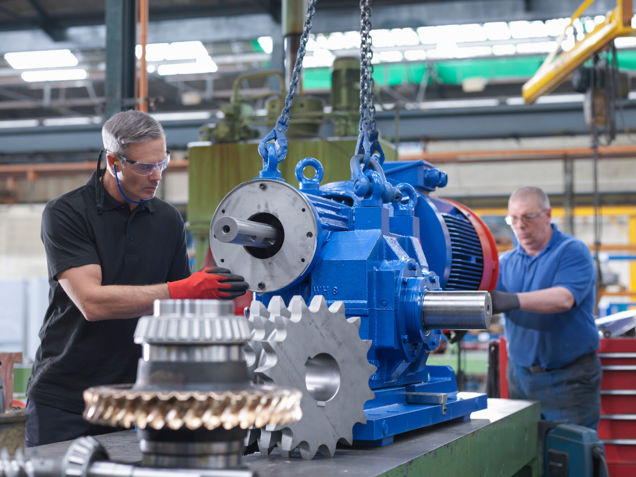 Zwei REFA-Ingenieure montieren einen Elektromotor in einer Fabrikhalle. (Diagrammart: Foto)