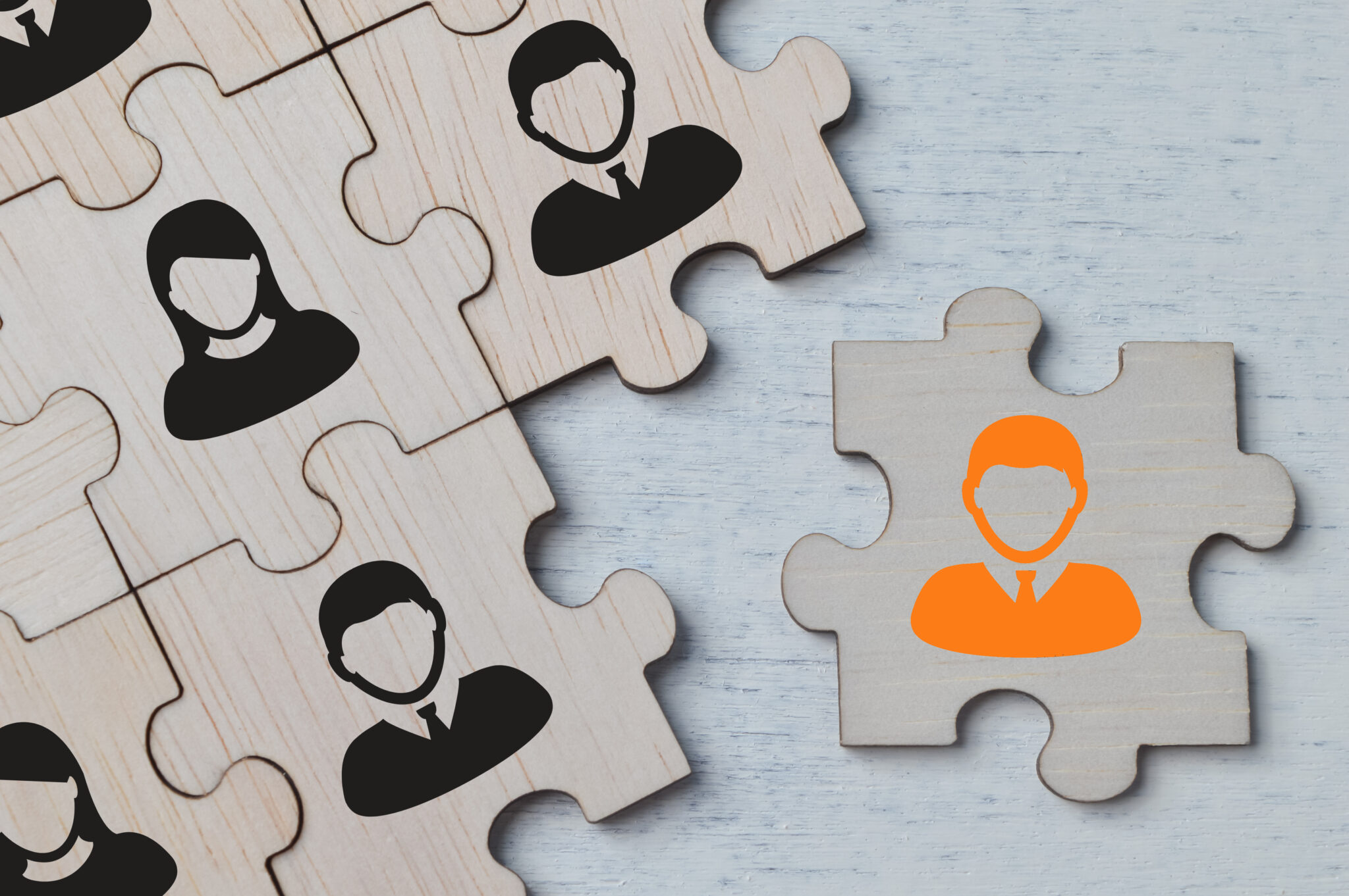 Illustration: Puzzleteil mit orangefarbener Figur passt nicht zu grauen Puzzleteilen, wenn falsche Personalberatung in der Medizintechnik gewählt wird.
