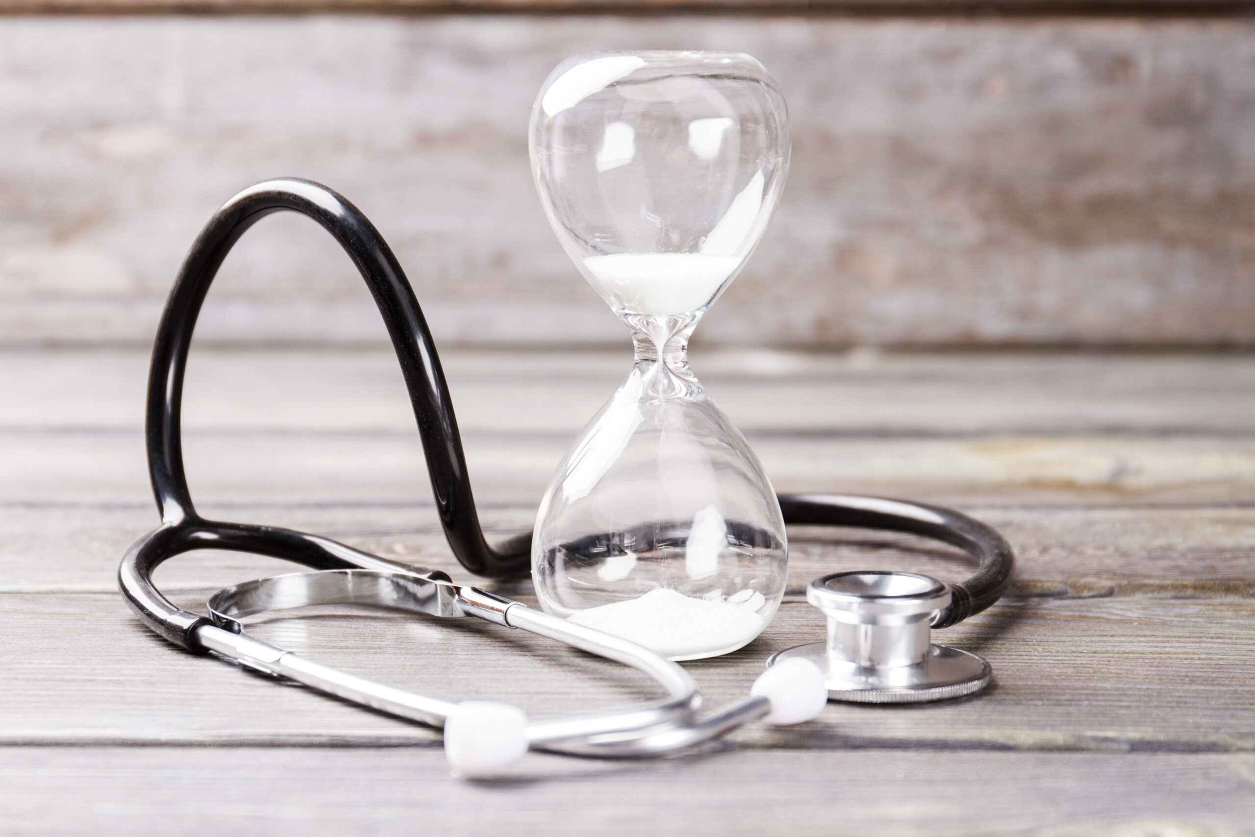 Symbolbild zum Ärztemangel mit Stethoskop und Sanduhr in Sepia