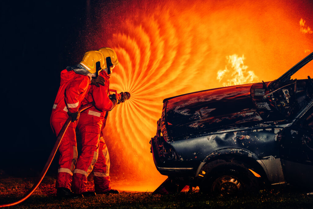 Zwei Werkfeuerwehrleute löschen einen Brand